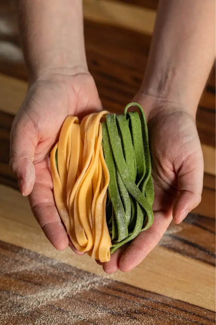 Chef Sofia Marinho segurando em suas mãos massas artesanais Fettuccine Paglia & Fieno.